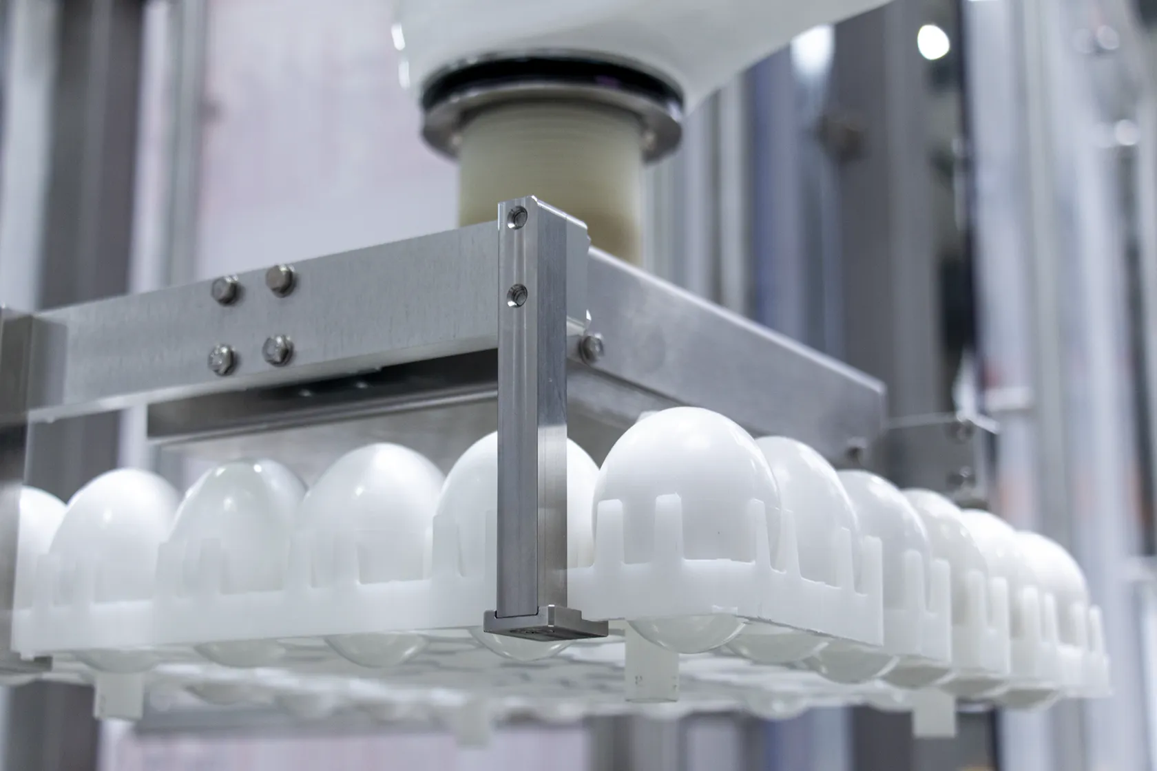 Detailaufnahme des Roboterwerkzeugs beim Griff um die Eierhorde